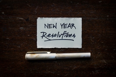 Handwritten New Year Resolutions note with a fountain pen on a wooden table, representing the deadline for business phone line migration