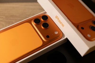 Orange iPhone in its box, representing the risks of relying on a personal mobile phone for business communications