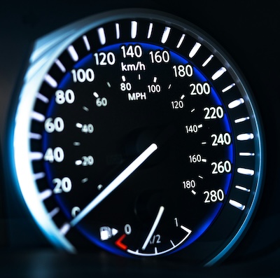 A close-up of a speedometer in a car, representing business growth acceleration with a virtual landline