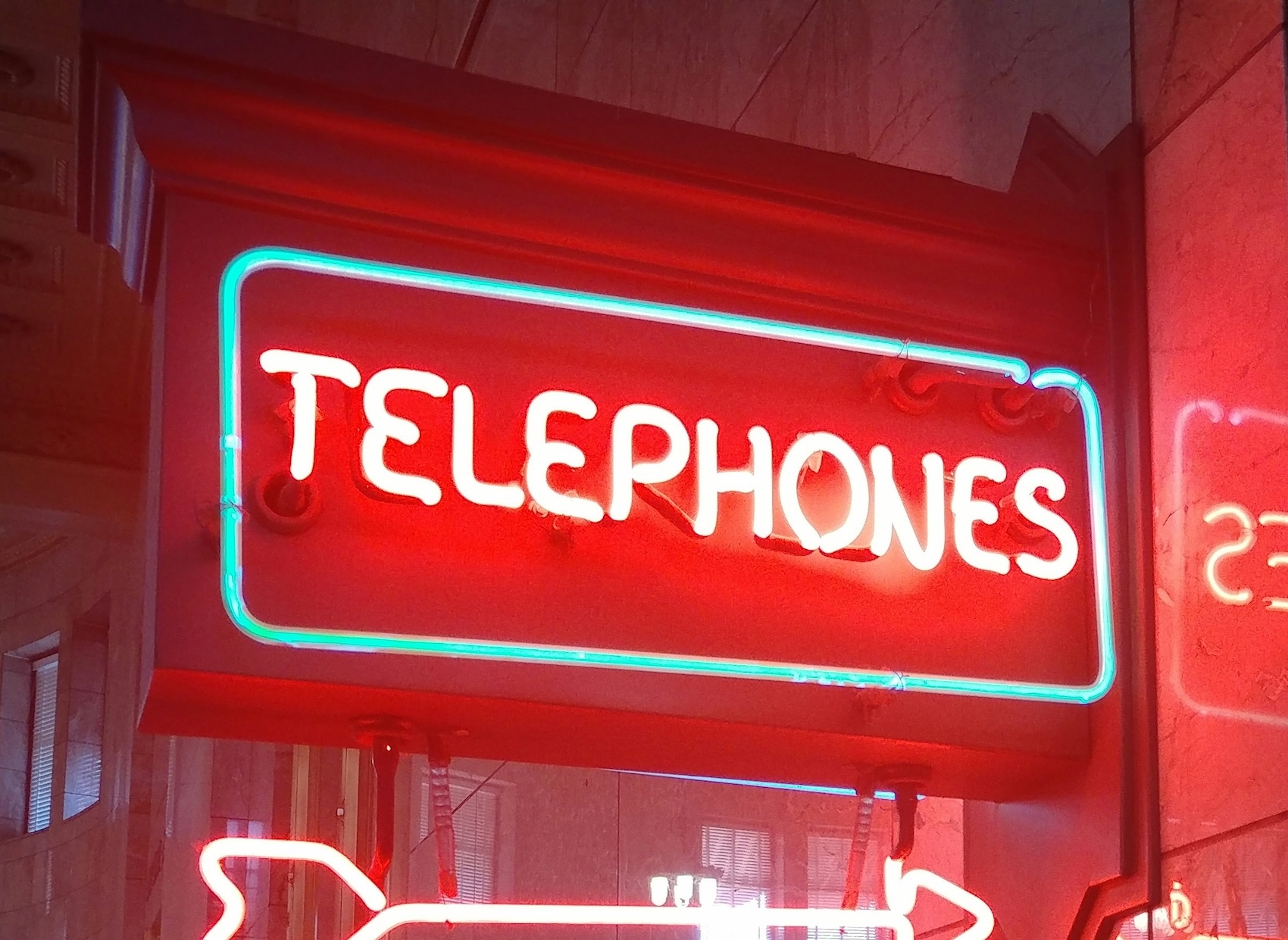 Neon Telephones sign with an arrow, representing the importance of having a dedicated business phone number