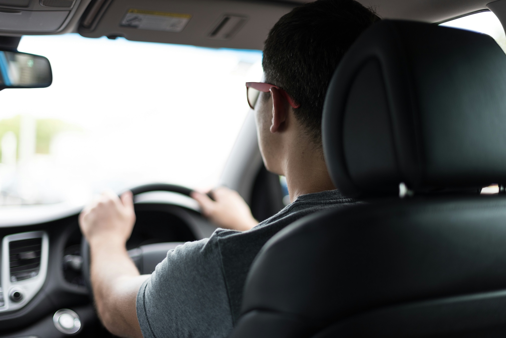 Man driving a car during daytime, representing driving instructors and driving lessons