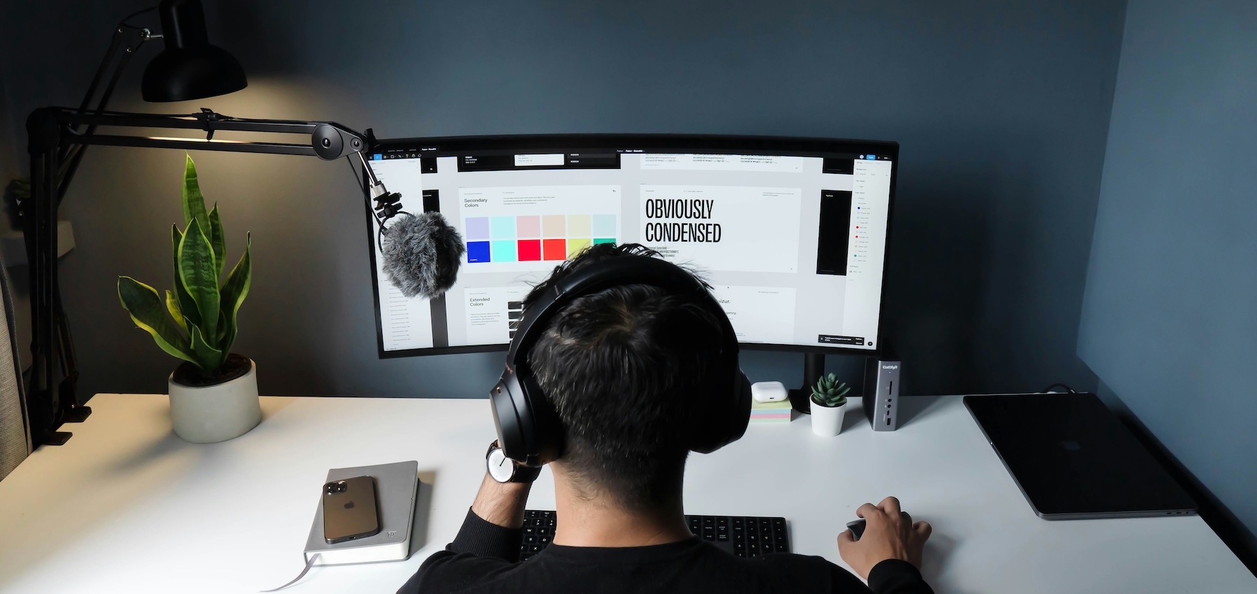 Freelancer wearing headphones working at a desk with a monitor and microphone, representing separating personal and business calls