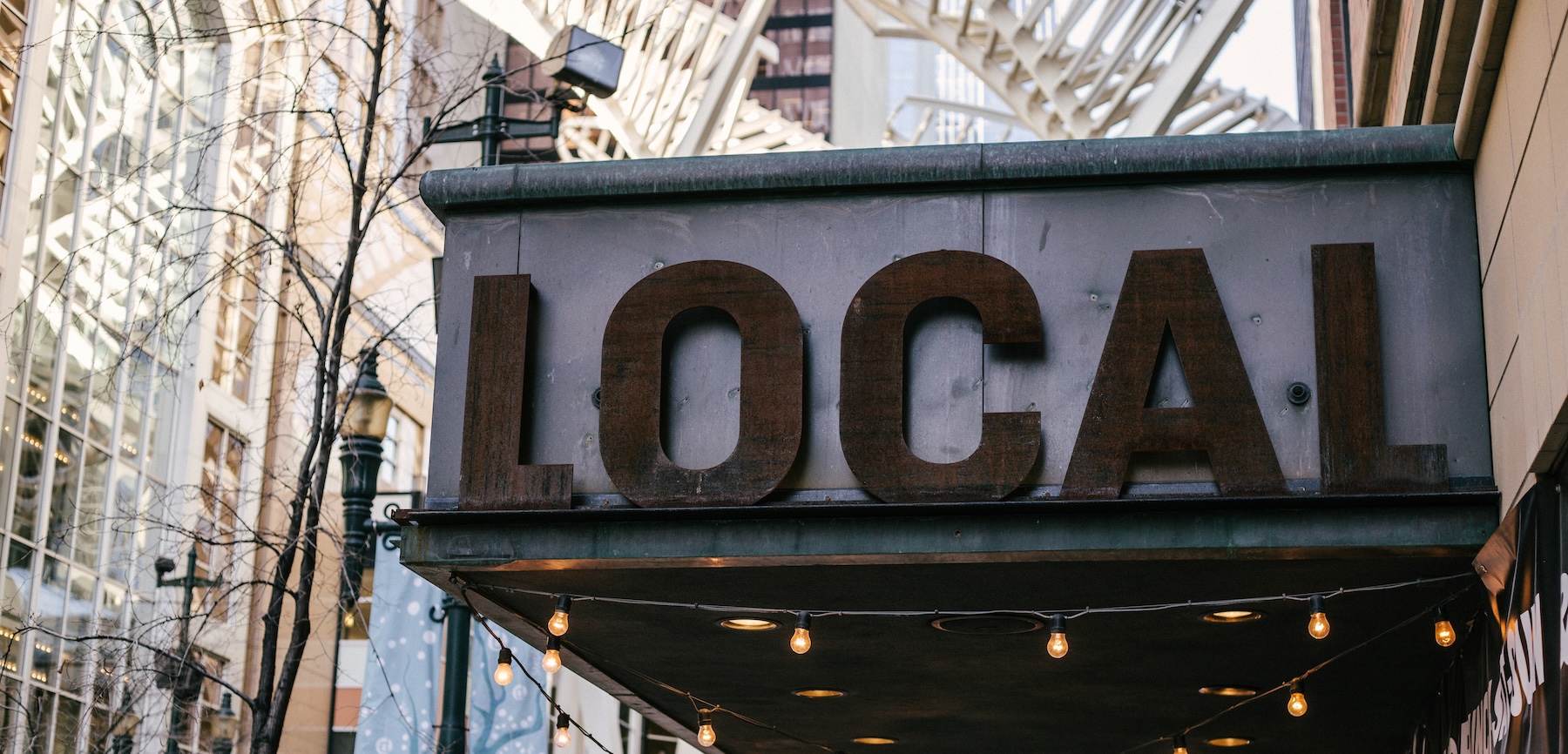 A gray and brown local sign, representing why customers prefer calling local business phone numbers