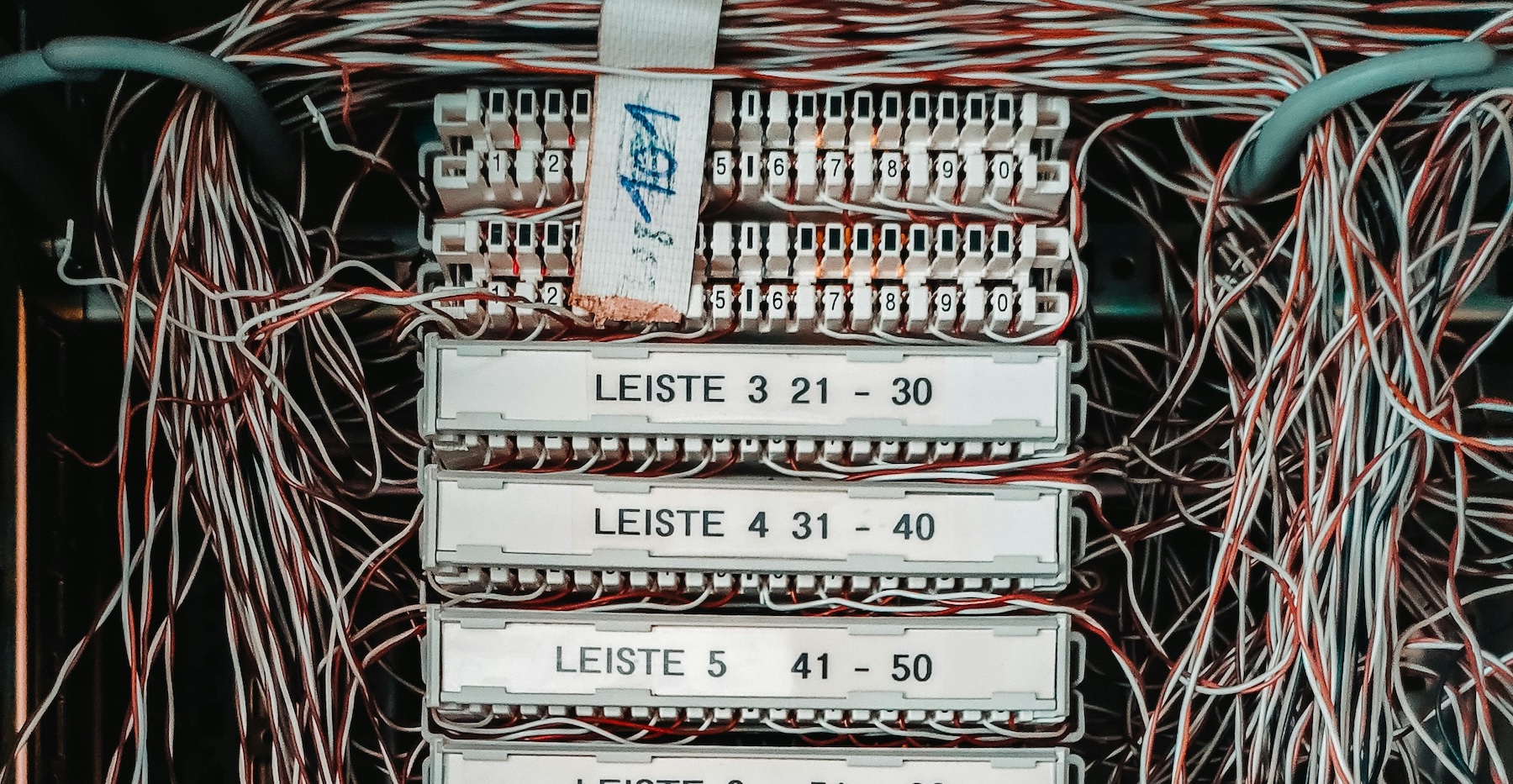 Telephone exchange patch panel with numbered terminal strips and coloured wiring, representing the copper PSTN network being switched off