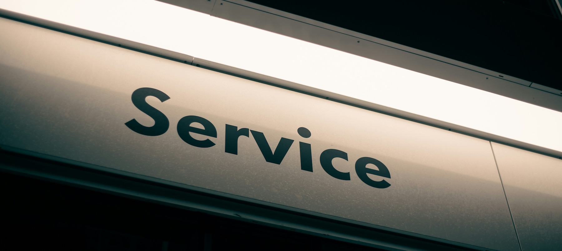 Illuminated Service sign on a building, representing local service businesses and customer trust