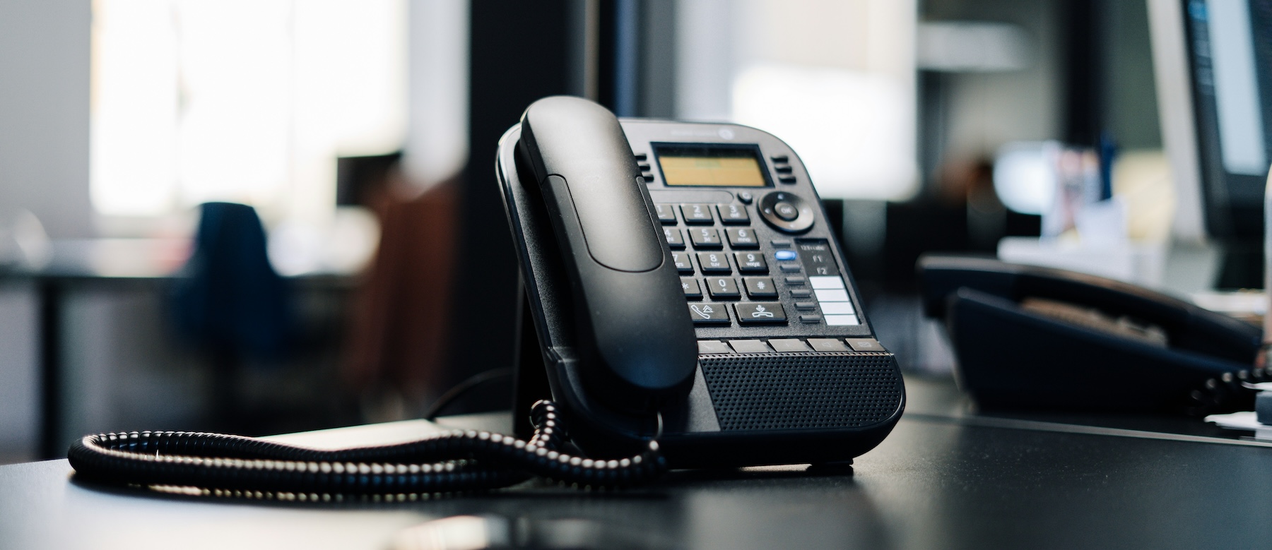 A desk phone on a table, representing the choice between traditional landlines and virtual phone numbers for startups