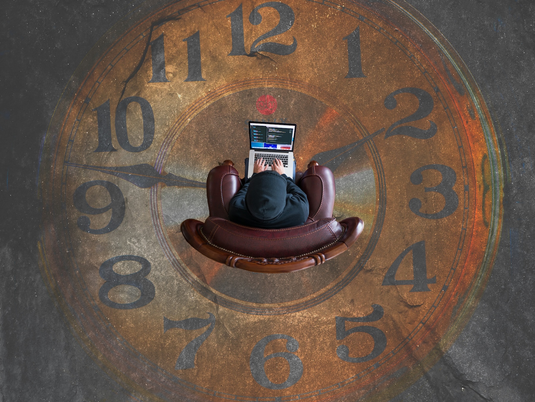 Person working on a laptop while sitting on a chair, overlaid on a large clock face, representing the PSTN switch-off countdown