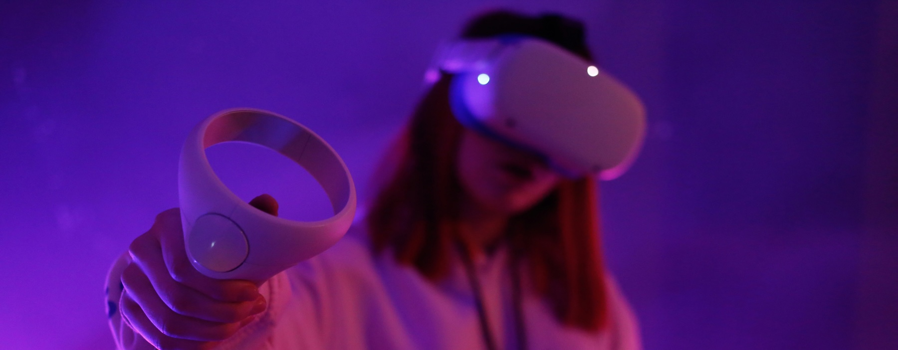 Person wearing a virtual reality headset in purple lighting, representing the virtual nature of modern business phone numbers