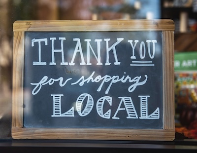 Open for business sign in front of a small shop representing how virtual phone numbers can benefit small businesses