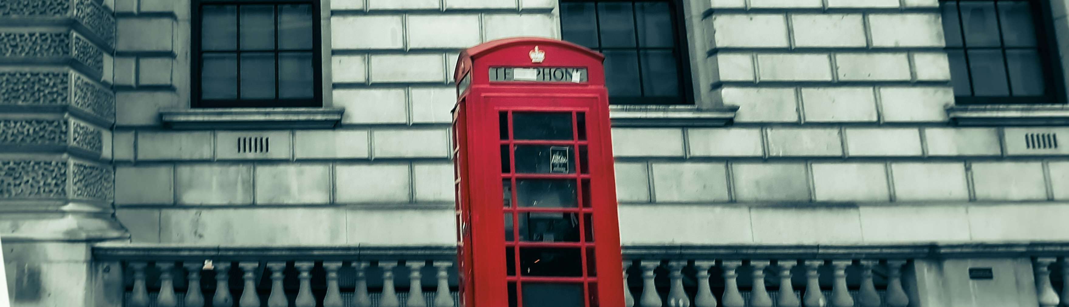 A London phone booth with a modern office building in the background, representing the relevance of local phone numbers for UK businesses
