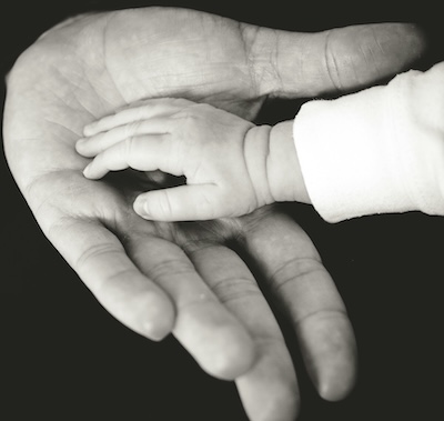 Hands of a parent and child together representing trust and connection, which can be influenced by local phone numbers for businesses
