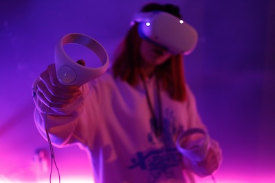 Person wearing a virtual reality headset in purple lighting, representing the virtual nature of modern business phone numbers